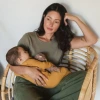 Image of mother sitting in a chair holding her child at her arms